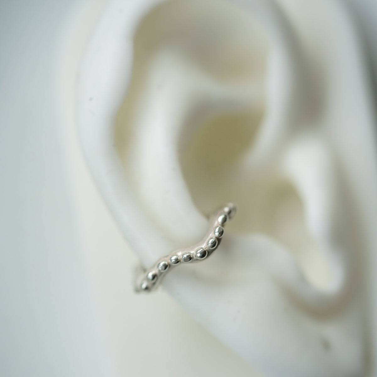 ACFJ Wavy silver ear cuff with beads on a ear lobe