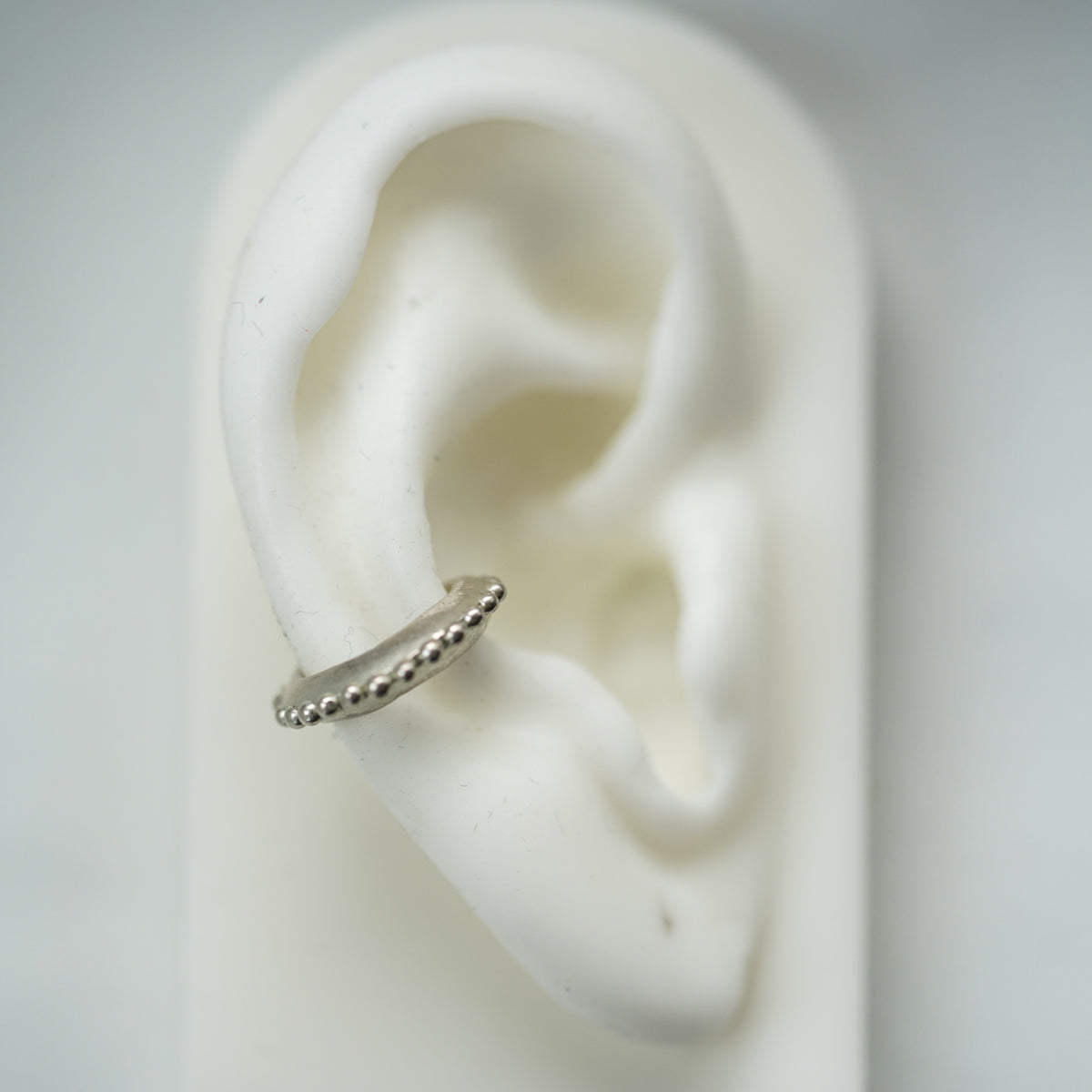 ACFJ silver ear cuff with beads on a ear