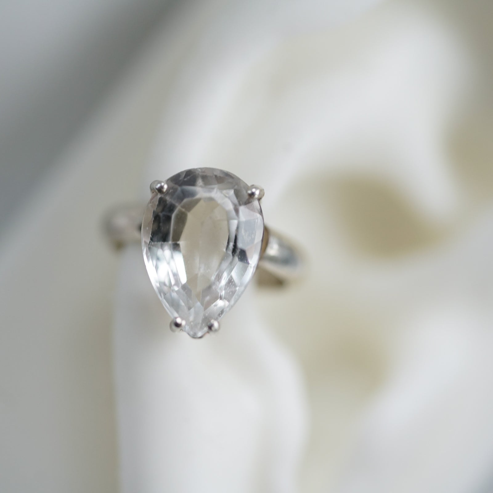 pear shape white topaz ear cuff in sterling silver on a ear lobe